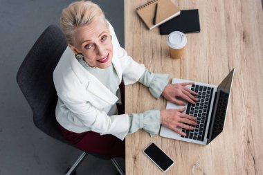 overhead view of elegant business woman working with laptop in modern office clipart