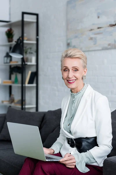 Elegante Donna Affari Sorridente Che Utilizza Computer Portatile Sul Divano — Foto stock gratuita