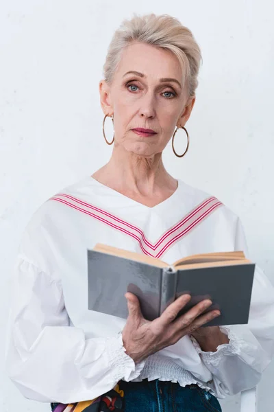 beautiful senior woman reading book, isolated on white