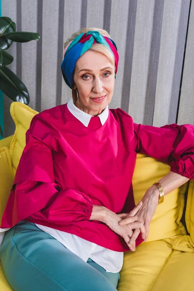 Modische Seniorin Sitzt Auf Gelbem Sofa Retro Stil — kostenloses Stockfoto