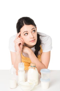 önlük ile tablo plastik kaplar, kase, şişe süt ve bebek şişeleri tapınakta parmağında çekici kadın 