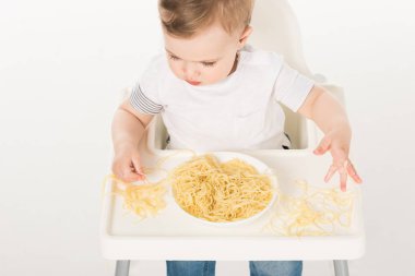 erkek bebek sandalyesi oturan ve eller tarafından spagetti yemek, yüksek açılı görünüş 