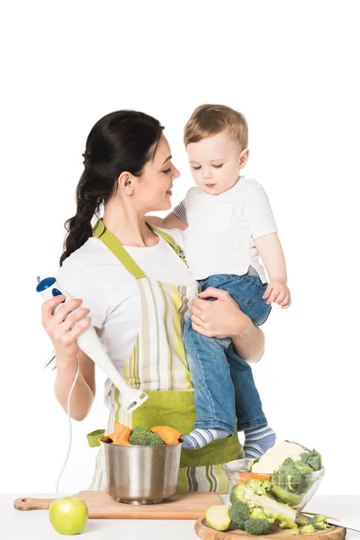 Smiling Mother Holding Son Hand Blender Table Apple Vegetables Isolated — Stock Photo, Image