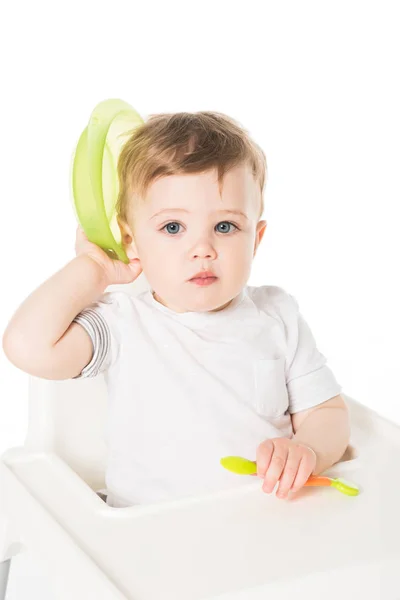 お皿やスプーンは 白い背景で隔離のハイチェアに座っている男の子の赤ちゃん — ストック写真