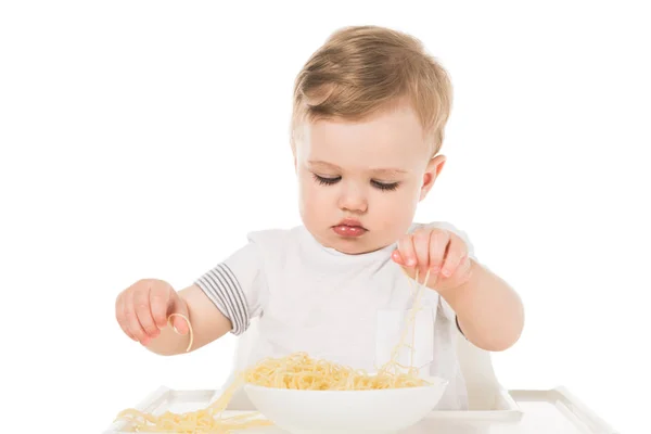 かわいい子の手でスパゲティを食べると 白い背景で隔離のハイチェアに座っています — ストック写真