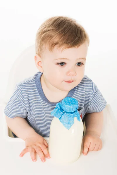 ミルク 白い背景で隔離のハイチェアに座ってのボトルと小さな男の子のハイアングル  — 無料ストックフォト