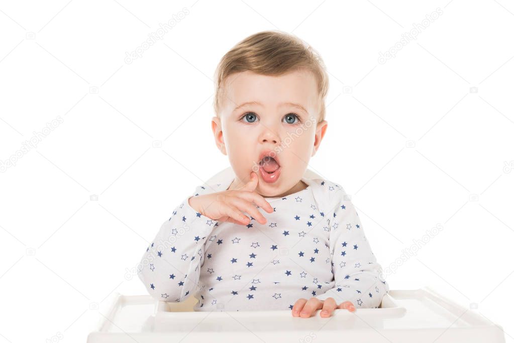 adorable little boy sitting in highchair isolated on white background 