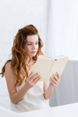 genç kadın evde kitap okuma konsantre