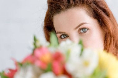 çiçek buketi bakmak ve kameraya bakarak güzel genç kadının yakın çekim shot