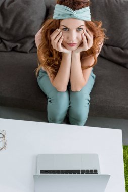 güzel genç kadının evde masa üstünde onu laptop ile kanepede oturan yüksek açılı görünüş