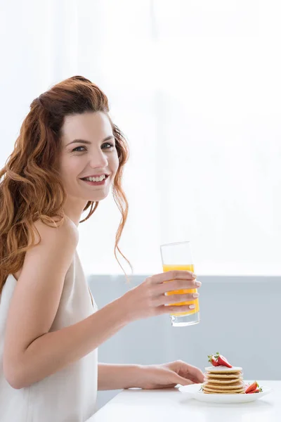 Jonge Vrouw Met Sinaasappelsap Pannenkoeken Met Aardbei Lachend Voor Ontbijt — Gratis stockfoto
