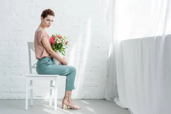 Sensuell Ung Kvinna Med Blommor Vas Framför Vit Tegelvägg — Stockfoto