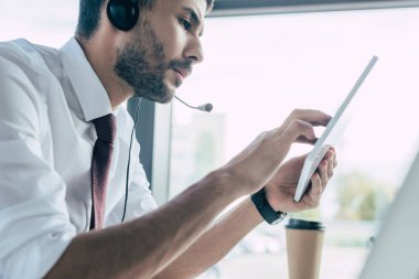 Dijital tablet kullanan ciddi çağrı merkezi operatörünün seçici odağı
