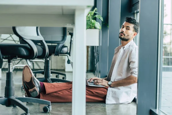 Selektivní Zaměření Podnikatele Sedícího Podlaze Laptopem Dívajícího Kamery — Stock fotografie