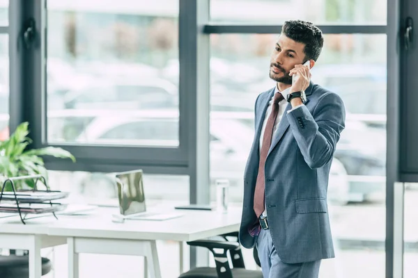 Serious Businessman Standing Desk Talking Smartphone — Stock Photo, Image