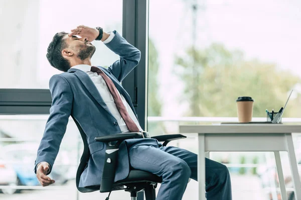 Erschöpfter Geschäftsmann Sitzt Arbeitsplatz Und Leidet Unter Kopfschmerzen — Stockfoto