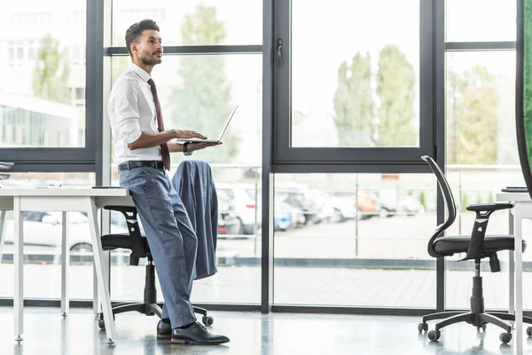 Confident Businessman Standing Desk Laptop Looking Away — 스톡 사진