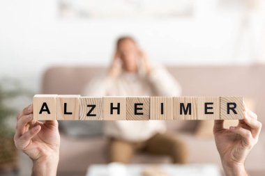 Alzheimer harfli ahşap küpler tutan yaşlı bir kadın görüntüsü. 