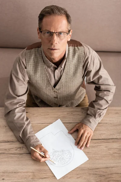 Ovanifrån Senior Man Glasögon Håller Penna Medan Ritar Bild — Stockfoto