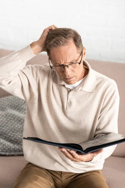 Nachdenklicher Mann Mit Alzheimer Brille Hält Fotoalbum Hause — Stockfoto