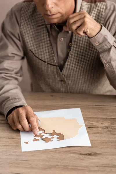 Beskärd Bild Senior Man Som Håller Glasögon Och Matchande Pusselbitar — Stockfoto