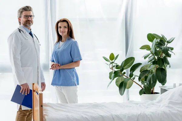 Lächelnder Arzt Weißen Mantel Und Attraktive Krankenschwester Blicken Krankenhaus Die — Stockfoto