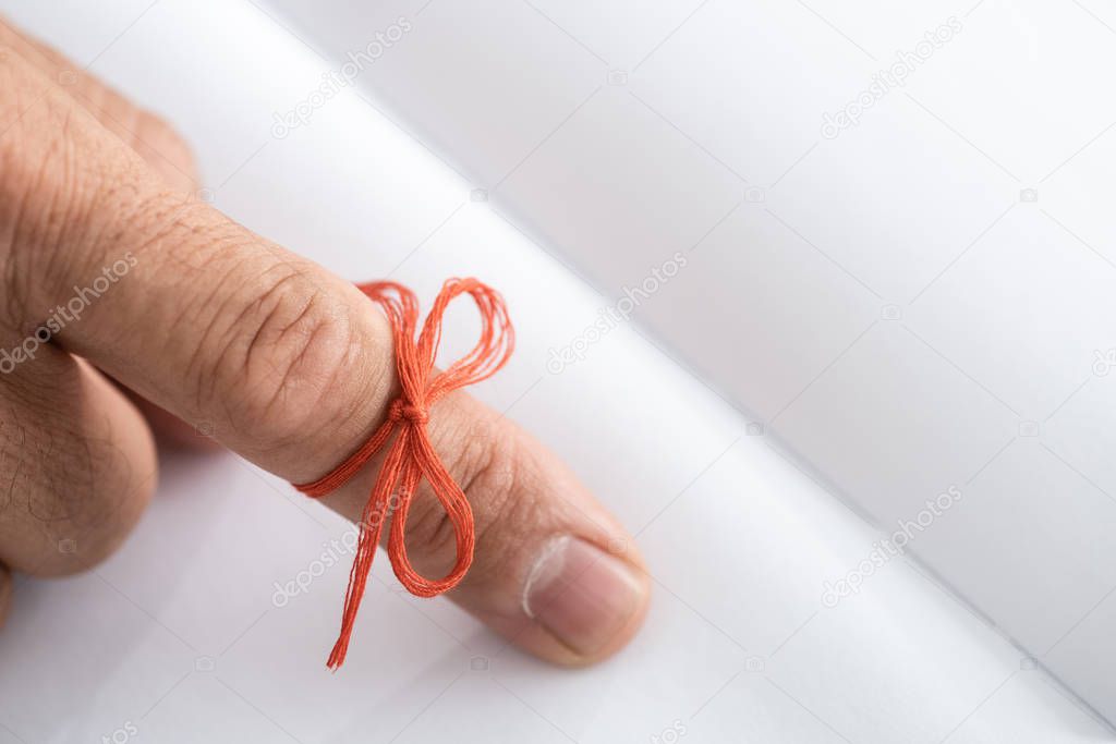 cropped view of senior man with alzheimers disease string human finger reminder near notebook 