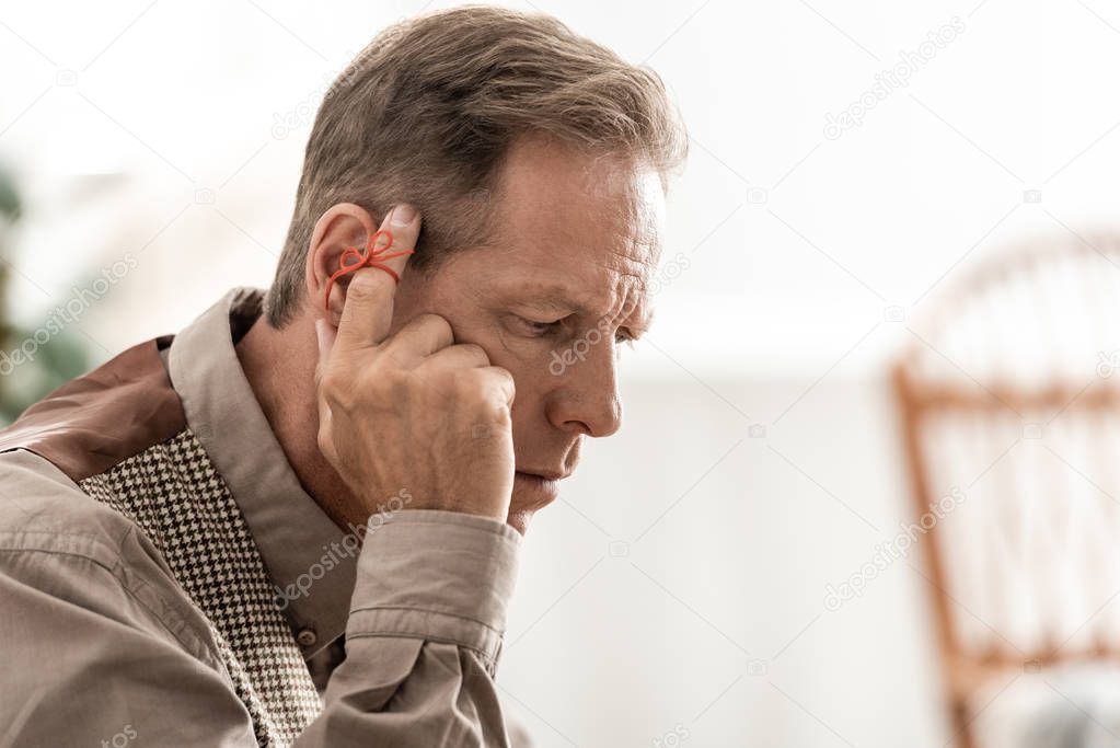 retired man with alzheimers disease string human finger reminder touching temple 