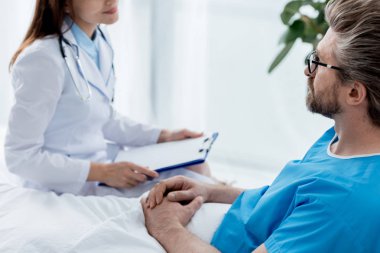 Beyaz önlüklü doktorun hastanedeki hastaya bakışı. 