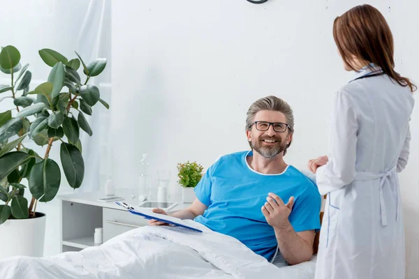 Visão Traseira Médico Casaco Branco Conversando Com Paciente Sorridente Hospital — Fotografia de Stock