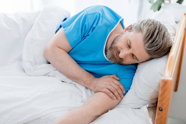 high angle view of patient in medical gown sleeping in hospital 