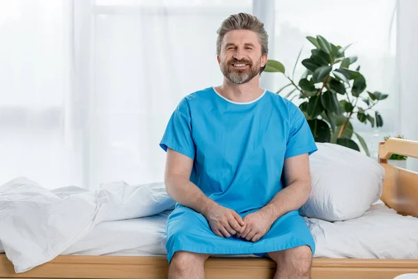 Paciente Sonriente Bata Médica Sentado Cama Mirando Cámara Hospital — Foto de Stock