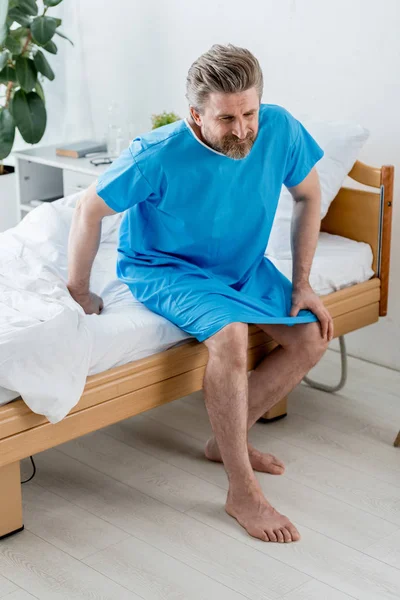 High Angle View Patient Medical Gown Sitting Bed Feeling Knee — Stock Photo, Image