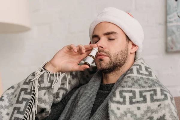 Unhealthy Man Santa Hat Wrapped Blanket Using Nasal Spray Closed — Stock Photo, Image