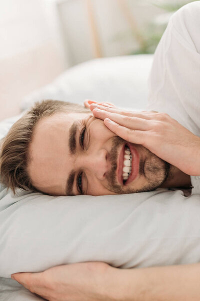 young man touching cheek while suffering from toothache