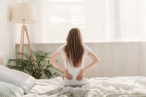 Вид Ззаду Молода Жінка Сидить Ліжку Страждає Від Болю Спині — стокове фото