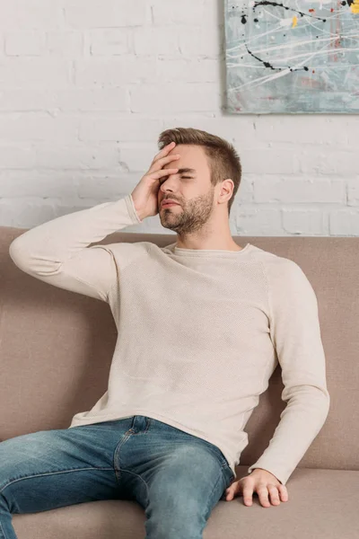 Young Man Sitting Sofa Closed Eyes While Suffering Migraine — Stock Photo, Image