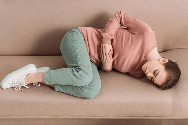 Unglückliche Frau Liegt Auf Sofa Während Sie Unter Bauchschmerzen Leidet — Stockfoto