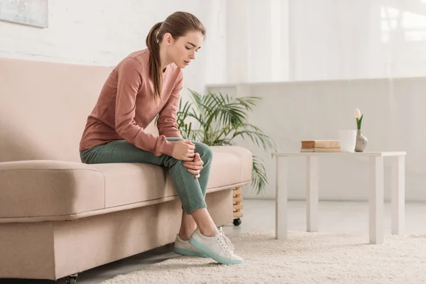 Upset Girl Sitting Sofa Suffering Knee Pain — Stock Photo, Image
