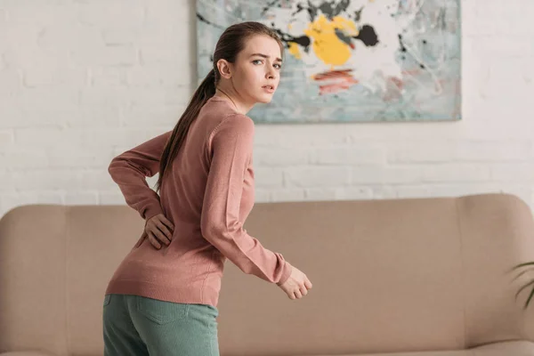 Mujer Joven Mirando Cámara Mientras Sufre Dolor Espalda — Foto de Stock