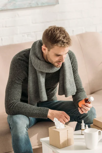 Kranker Mann Sitzt Auf Sofa Und Blickt Auf Flasche Mit — Stockfoto