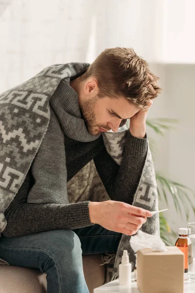 Ill Unhappy Man Wrapped Blanket Looking Thermometer While Sitting Table — Stock Photo, Image