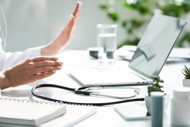 Doktorun, klinikte dizüstü bilgisayarında hastayla çevrimiçi istişare yaptığı görüntüler.
