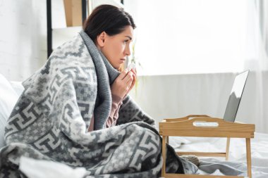 Güzel hasta kadın dizüstü bilgisayarında doktorla görüşüyor.