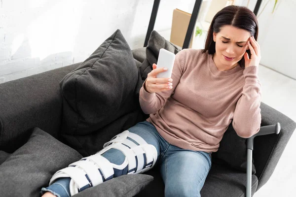 Stressed Woman Headache Broken Leg Having Online Consultation Doctor Smartphone — Stock Photo, Image