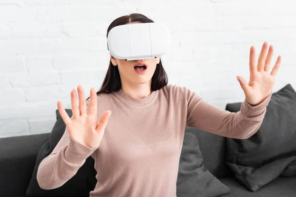 Mulher Chocada Usando Realidade Virtual Headset Enquanto Sentado Sofá — Fotografia de Stock