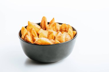 delicious golden potato wedges in bowl on white background clipart