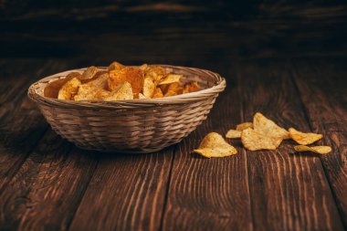 Tahta masada hasır sepette patates cipsi.