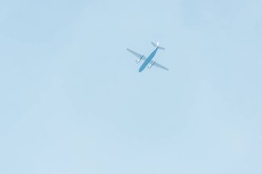 Arka planda mavi gökyüzü olan uçağın alt görüntüsü