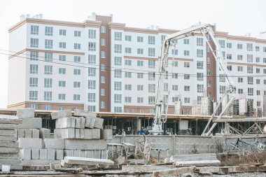 Construction site with crane and concrete blocks clipart